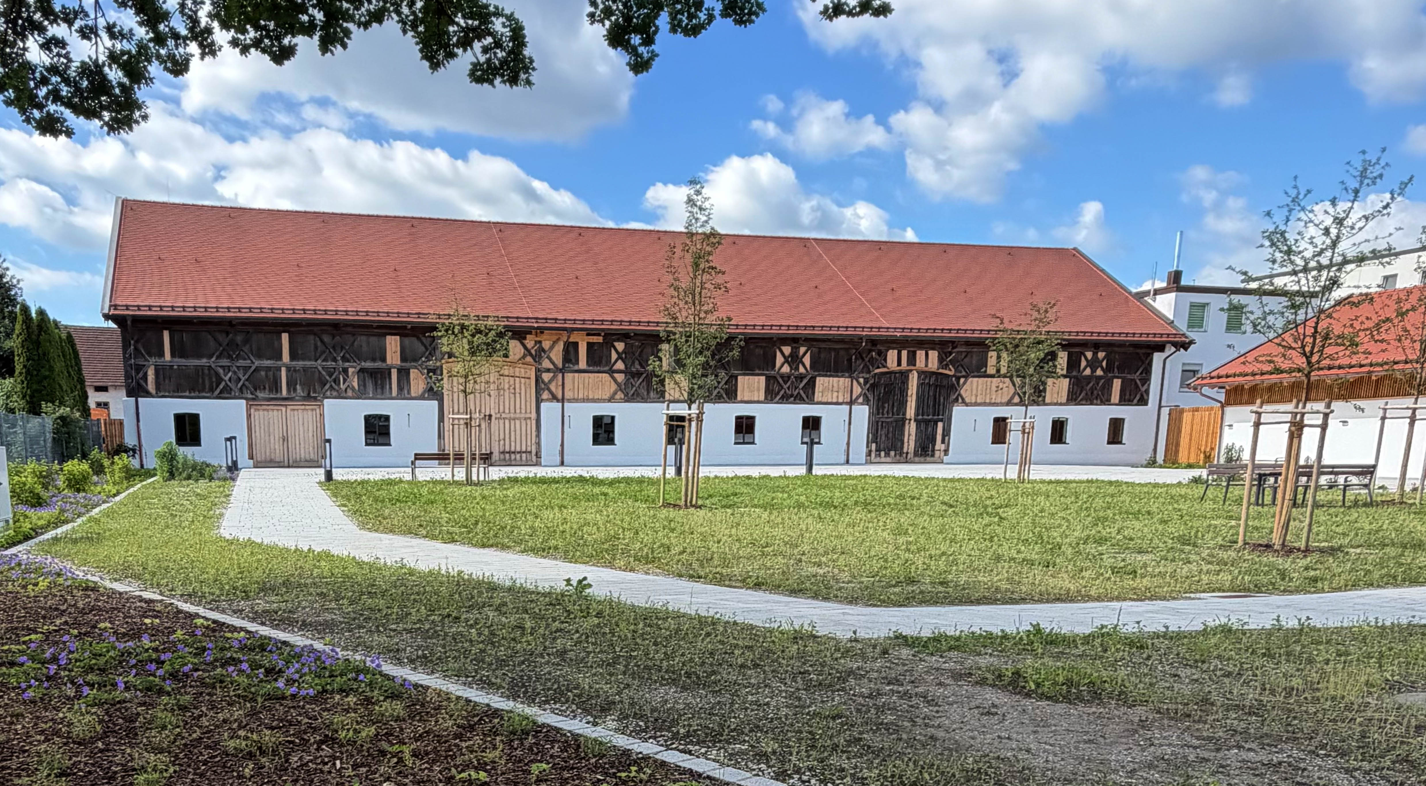 Zitzmerstadl nach der Sanierung – Blick auf den Hof mit Grünanlage und gepflastertem Weg